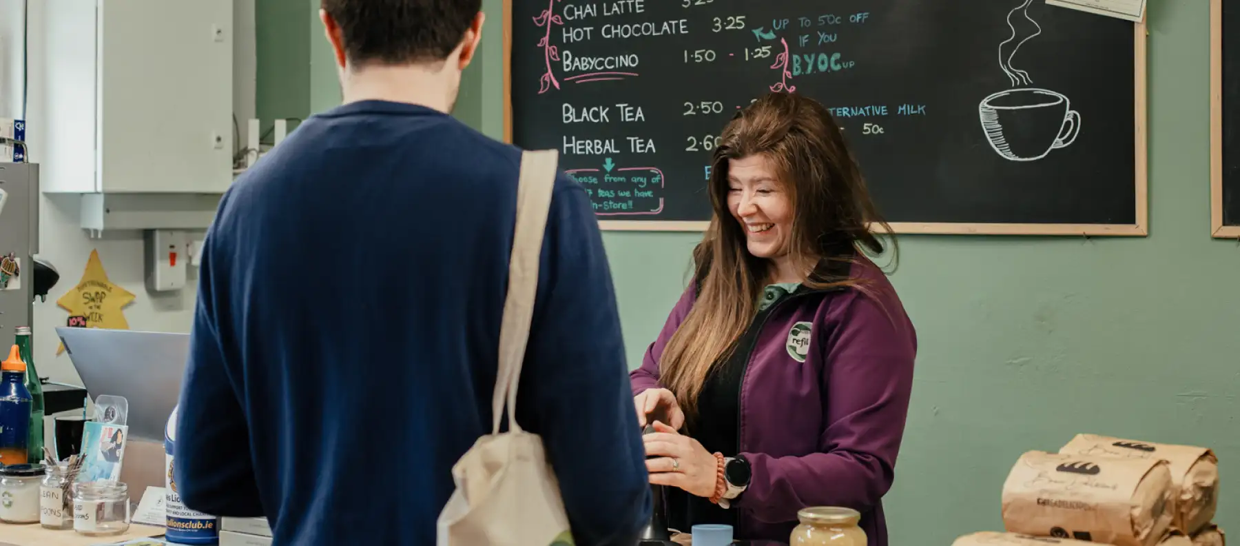 Woman serving coffee and smiling at a repair cafe